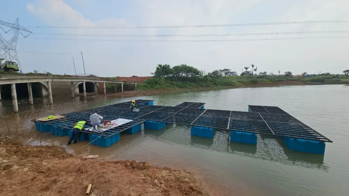 Pekerja merakit rangka di atas rangkaian ponton biru pada proyek dermaga apung di Serpong