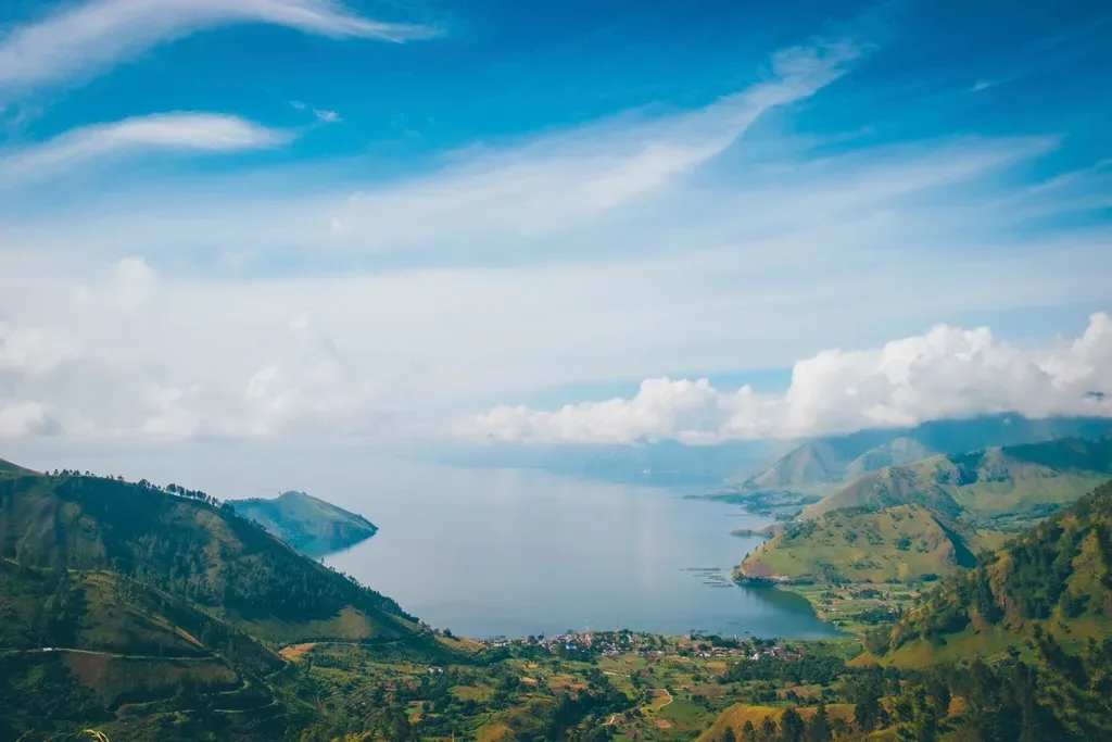 Pemandangan udara Danau Toba dengan perbukitan hijau di sekelilingnya