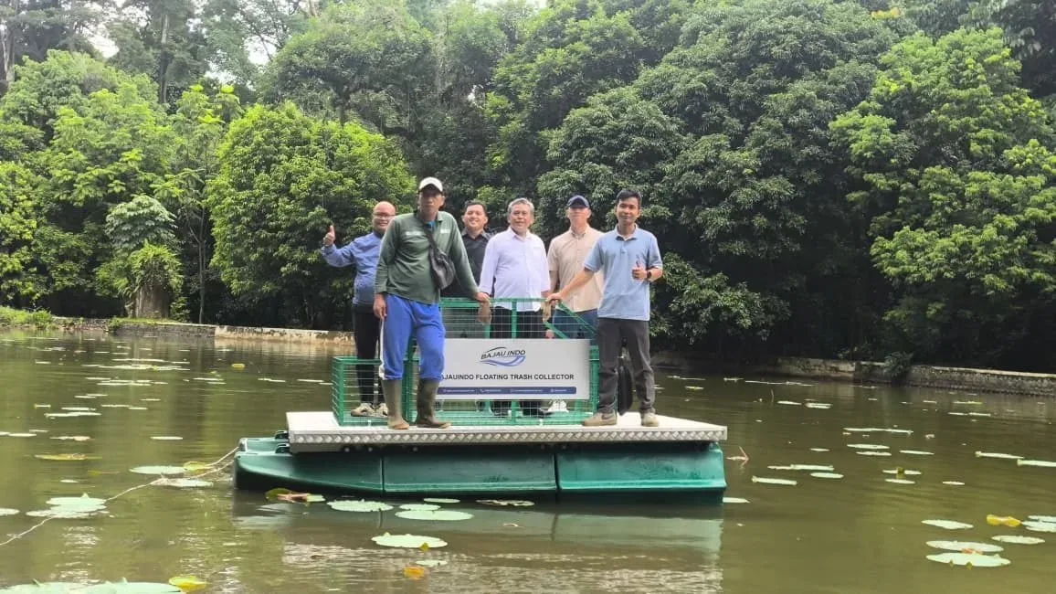 Platform trash collector manual berukuran kecil dengan lima orang berdiri di atasnya