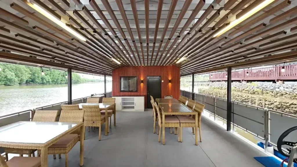 Interior restoran terapung dengan deretan meja makan dan plafon kayu