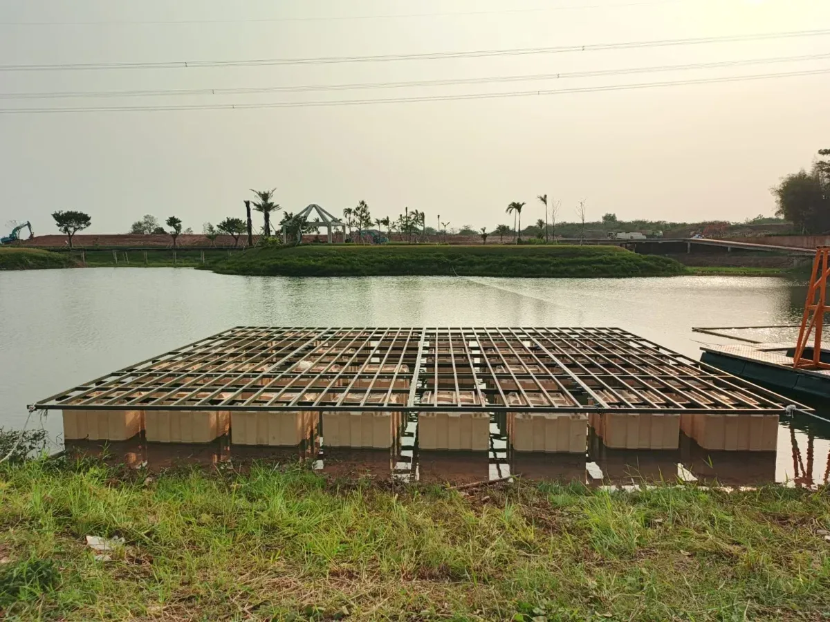 Ponton krem di danau dengan rangka logam gelap terpasang di atasnya saat proses pemasangan