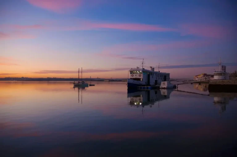 white and black wooden house on body of water during sunset